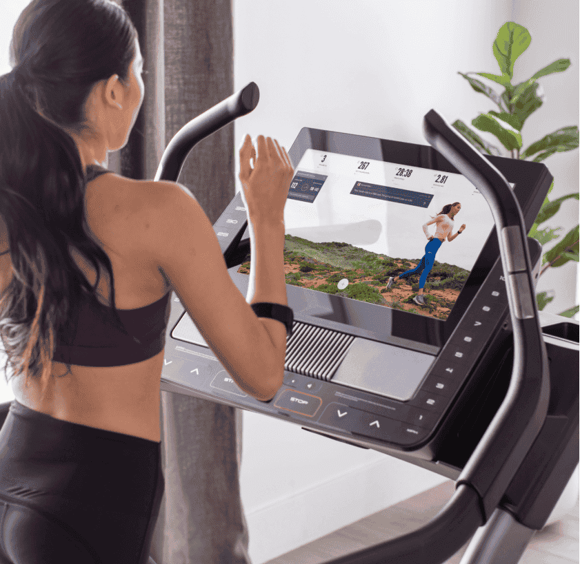 Woman does an iFIT running workout on a treadmill