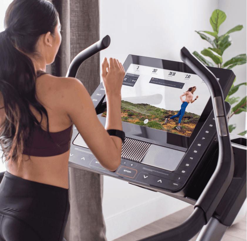 Woman does an iFIT running workout on a treadmill