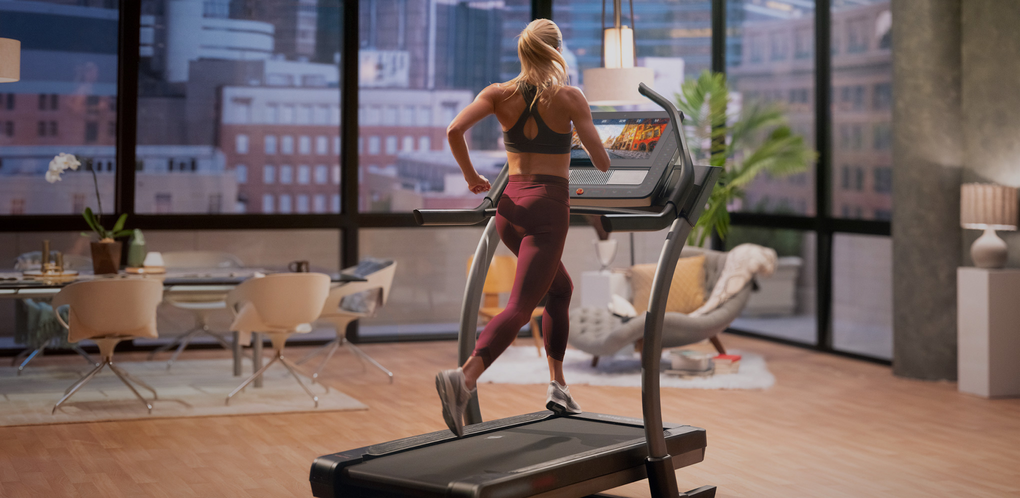 Woman does an iFIT running workout using Google Maps on her treadmill