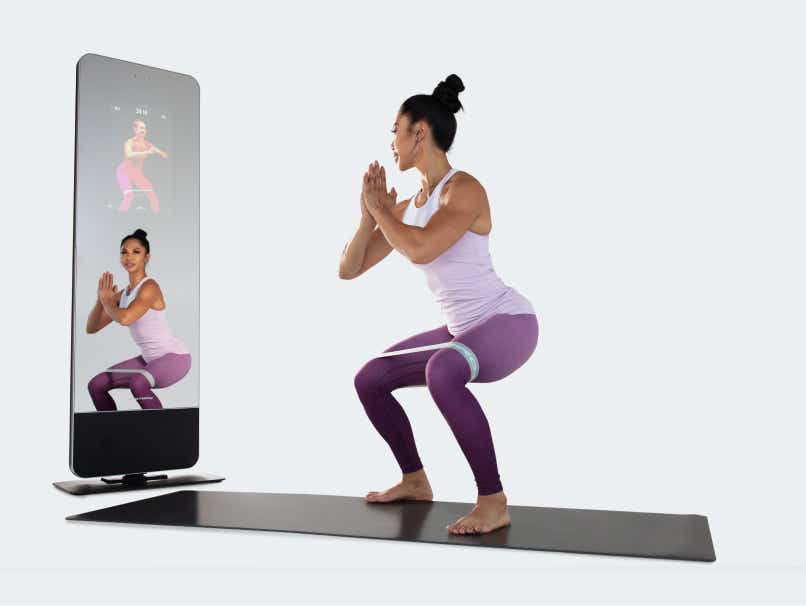 Woman using interactive fitness mirror