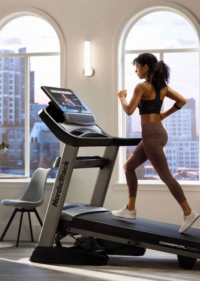 Woman running on NordicTrack treadmill in apartment
