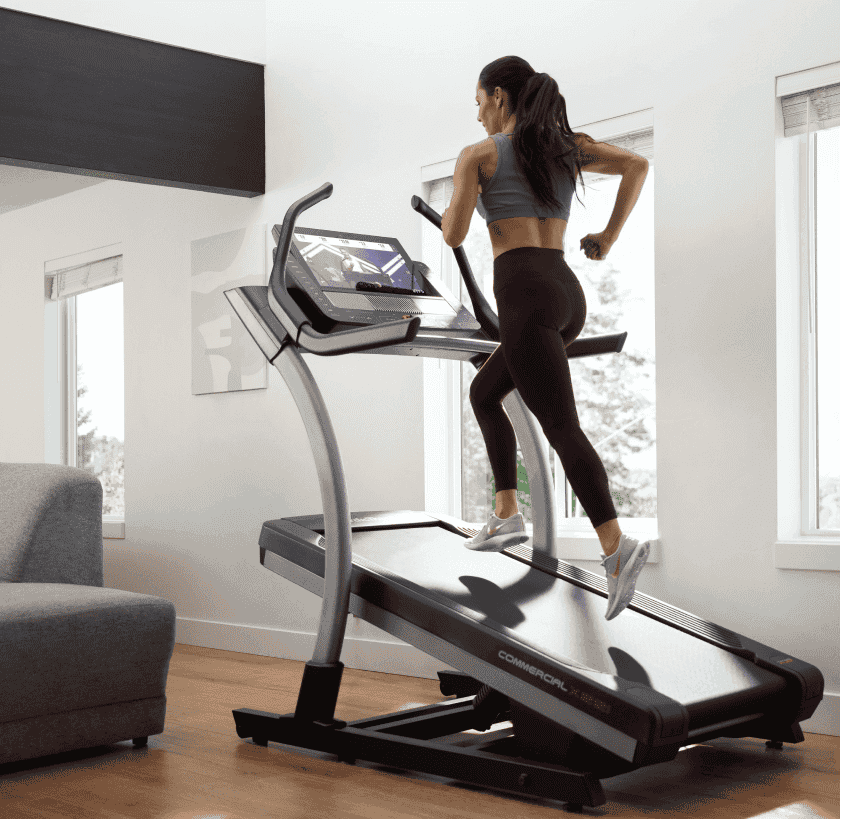 Woman does an iFIT treadmill workout with LiveAdjust