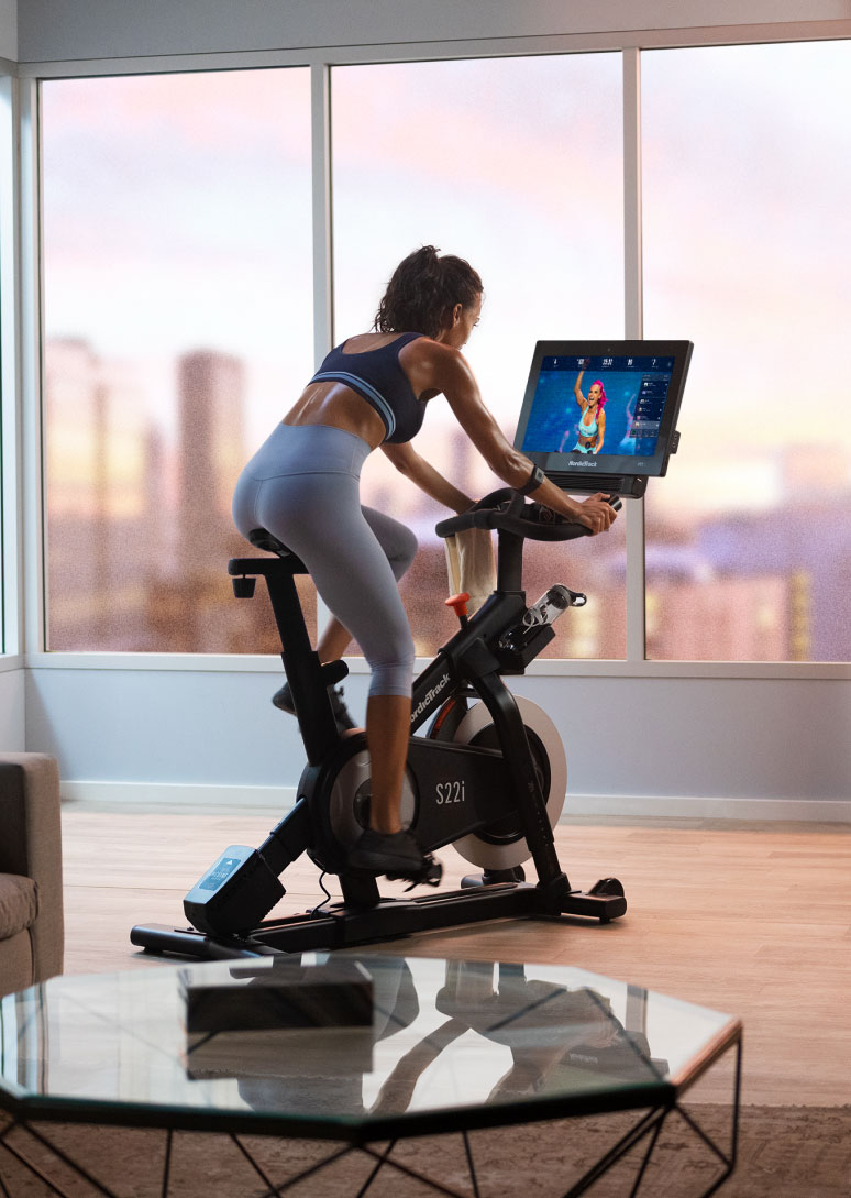 Woman riding exercise bike in her bedroom