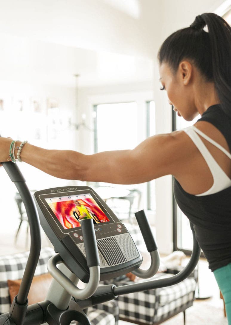 Woman using elliptical machine