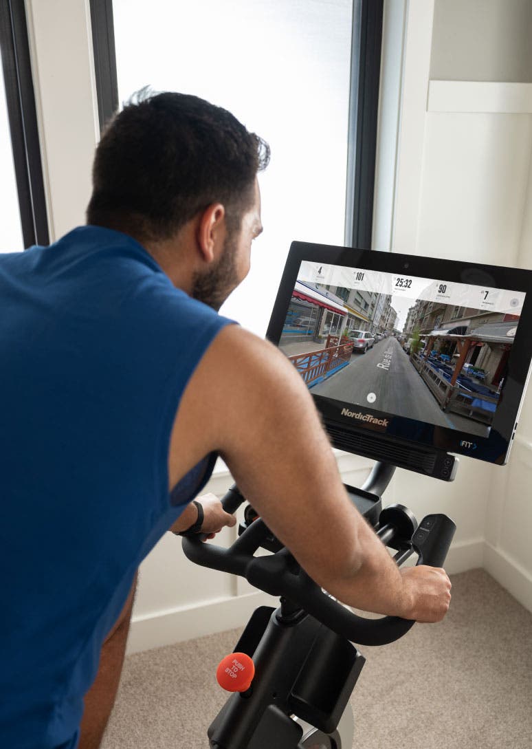 Man rides NordicTrack bike while viewing Google Maps