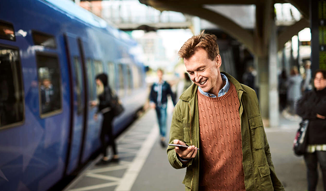 Man using his smartphone at the train station.