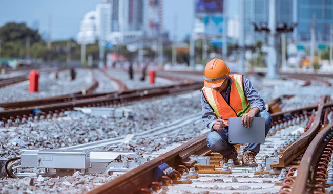 Man inspecting rail trail in city.