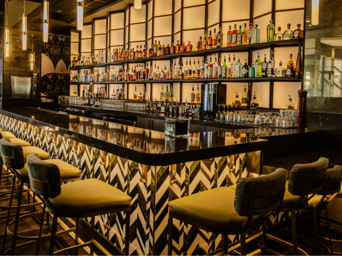 Contemporary luxe bar at Carvers on 19 featuring an extensive selection of spirits, stunning ambience, and captivating details for a vibrant night out