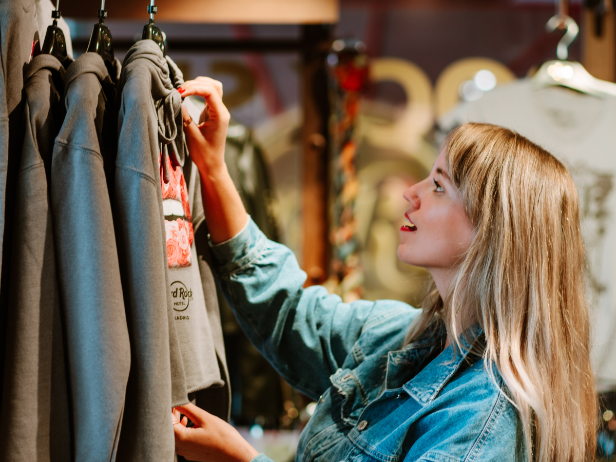Girl grabbing clothes from rack