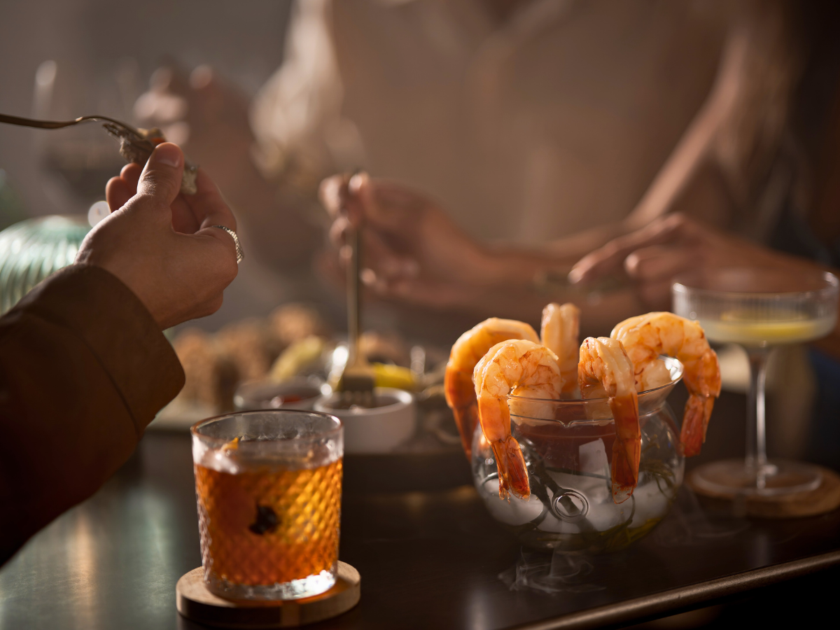 A chilled shrimp cocktail served alongside a classic Old Fashioned, presented with Carvers on 19’s signature elevated style