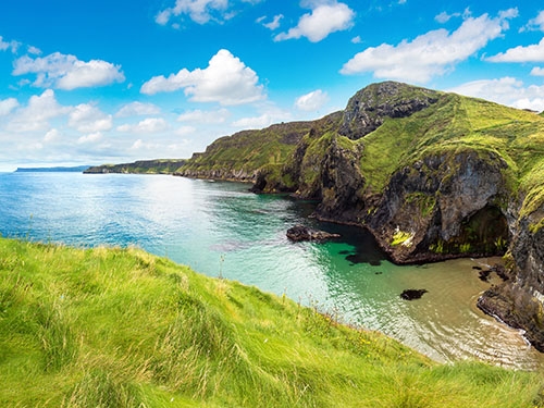 Magnificient seaside cliffs, covered in green grass, on the Causeway Coast