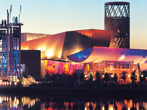 The Lowry venue in Manchester lit up in pink, blue and orange lights 