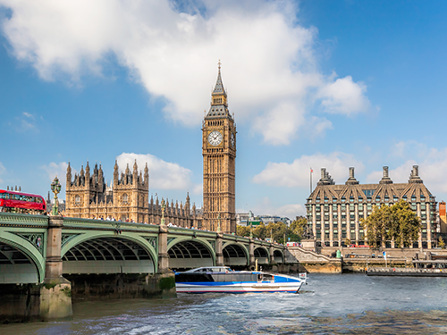 Big Ben and London Bridge pictured from the other side of the water on a bright sunny day