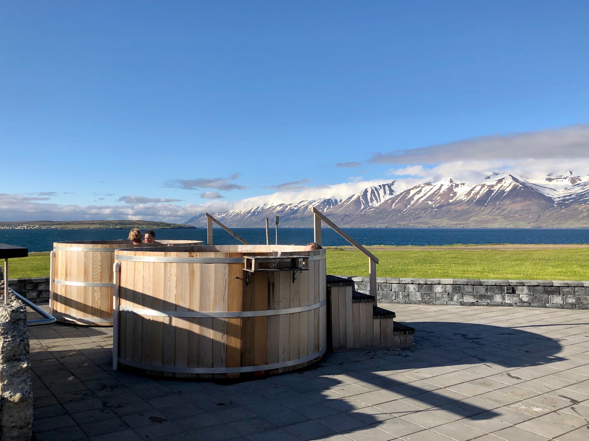 The outdoor spa baths at Bjórböðin beer spa in north Iceland, with fjord and mountain views