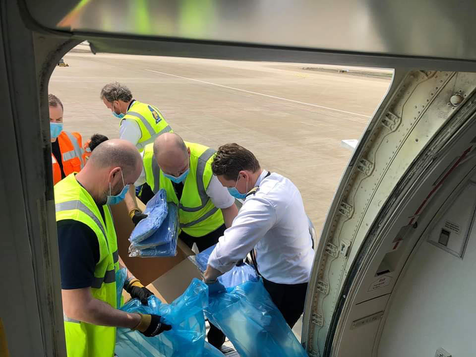 A view from within the aircraft cabin of the staff working to package PPC for healthcare workers