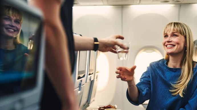 a passenger eats a meal from the in-flight menu