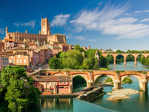 Albi Cathedral in Southern France by the river Tarn. Stately medieval bridges over the river.