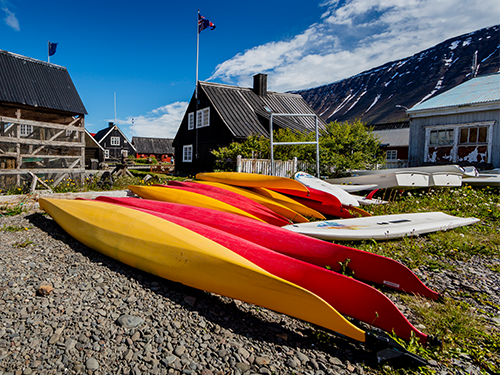 The Westfjords Heritage Museum pictured on a bright day with colourful canoes pictured in the foreground 