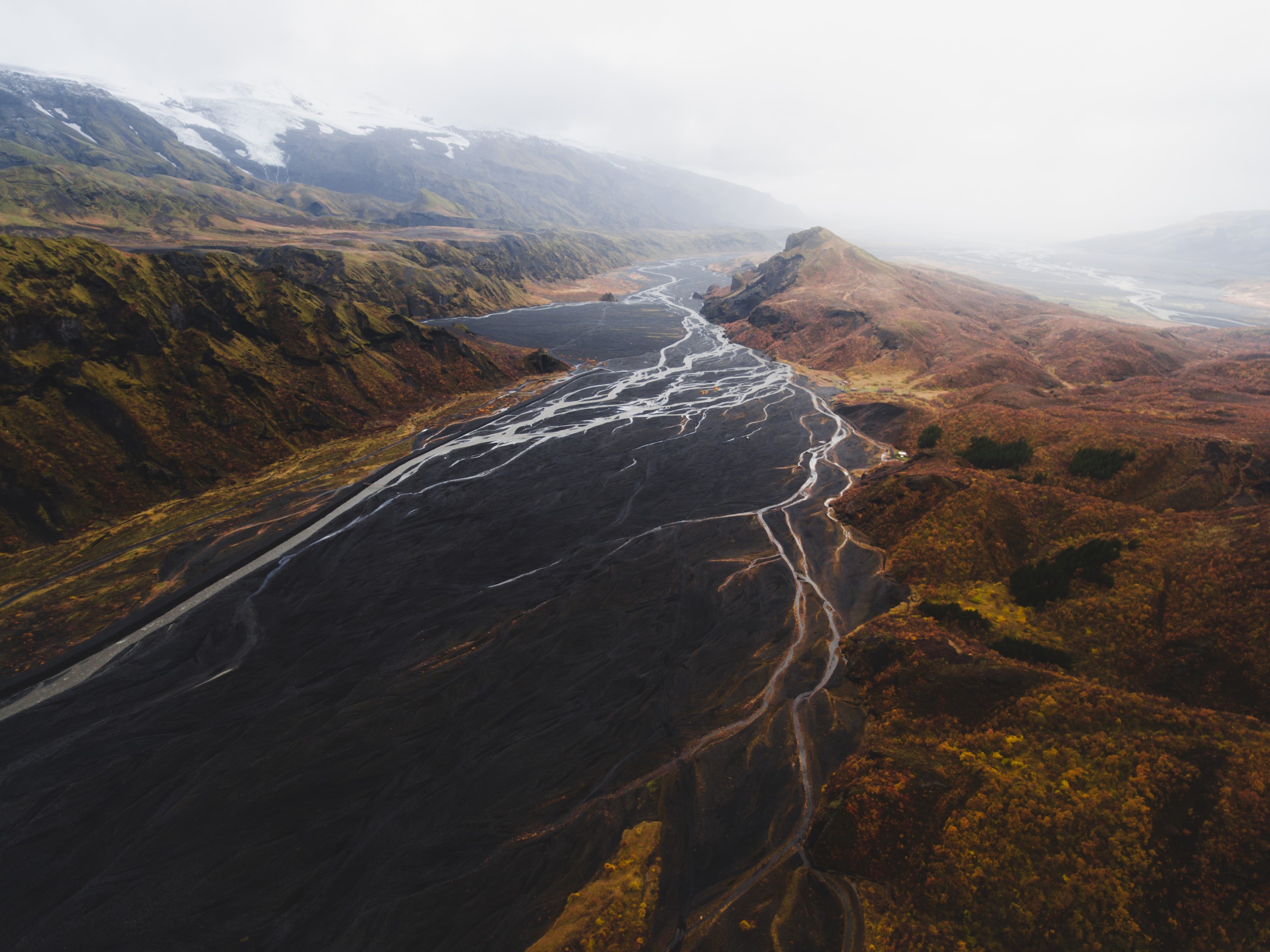 an aerial view of the mountains and glacier rivers at Langidalur and Valahnukur in Thorsmork, Iceland