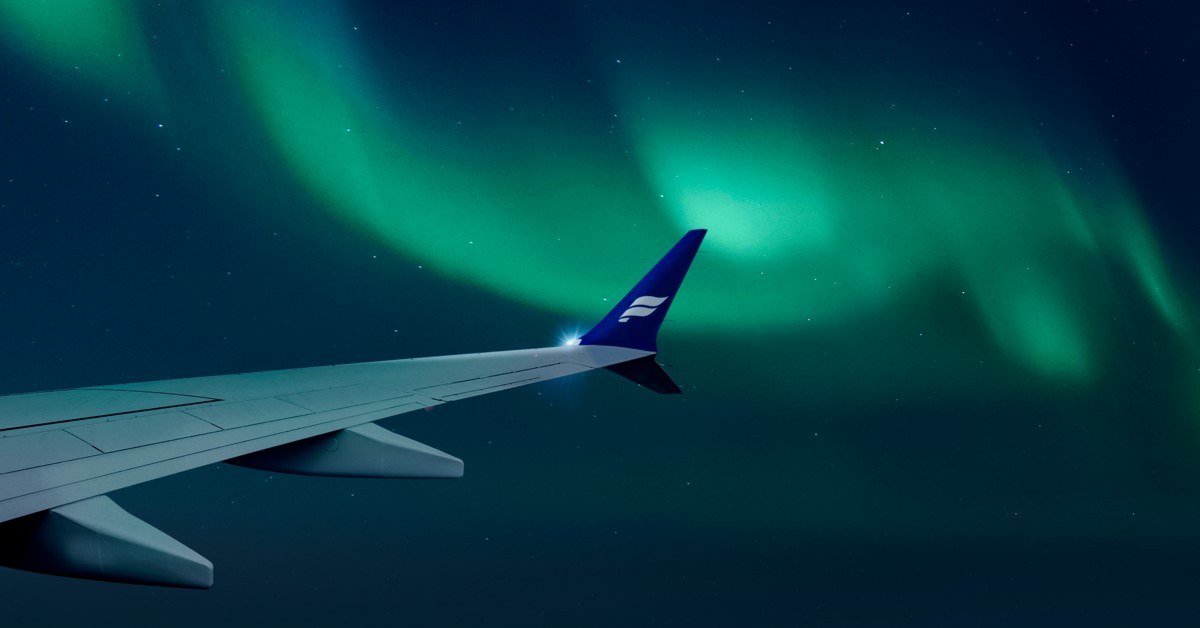 a winglet of an Icelandair plane with a view of the northern lights