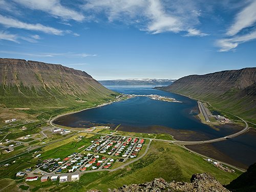 An overhead view of the town of Ísafjörður, as pictured from behind the town looking out over the surrounding fjords