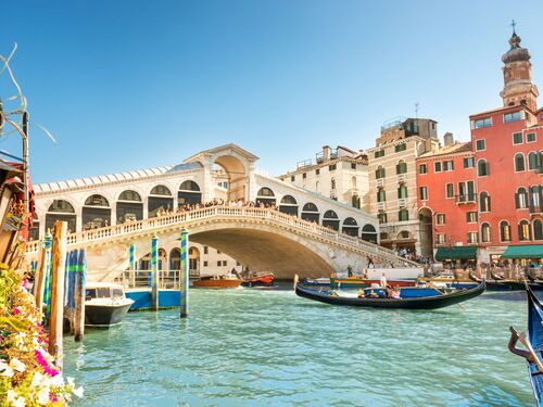 The historic Rialto Bridge in Venice stretching across blue-green water