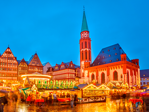 One of the bustling Christmas markets in Frankfurt, Germany lit up against the evening light 