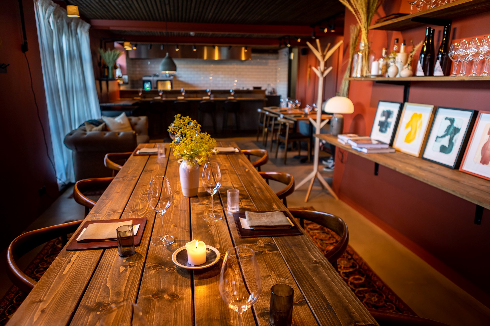 The rustic interior of North restaurant, with wooden table in the foreground and open kitchen in the background