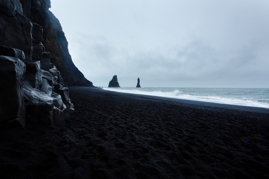 Reynisfjara black sand beach, pictured with waves crashing against the shore, an iconic location from Disney's Frozen film
