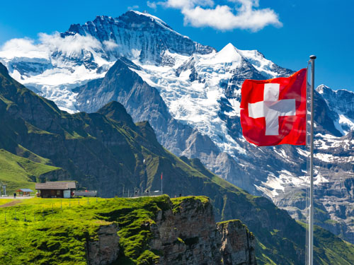 the swiss flag with alps in background