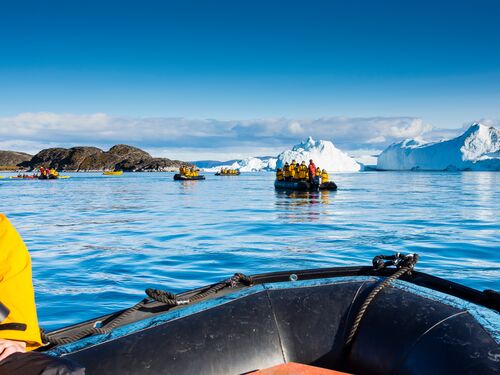 travellers get up close and personal with icebergs in the ocean near Ilulissat