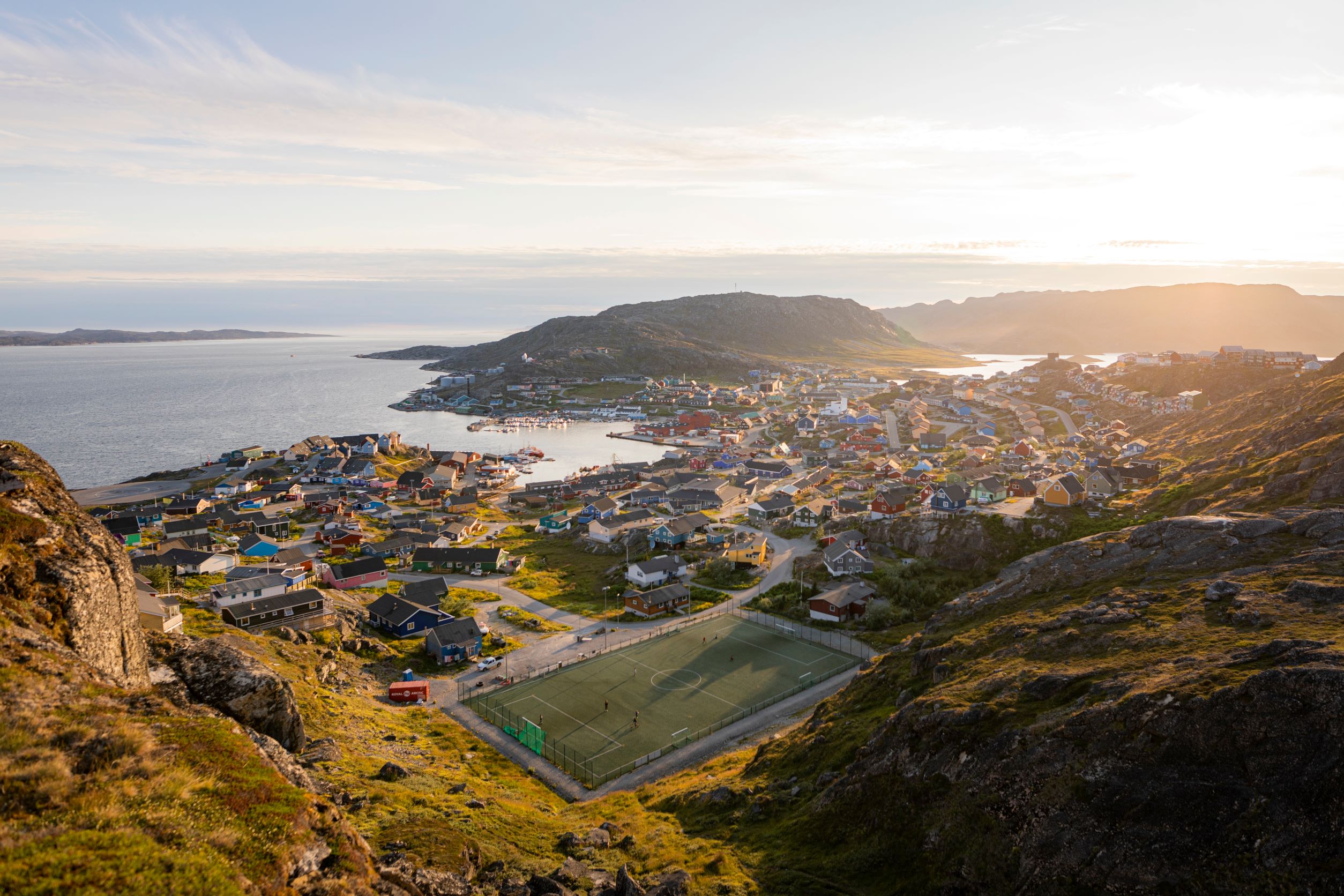 an aerial view of the football field and town of Qaqortoq