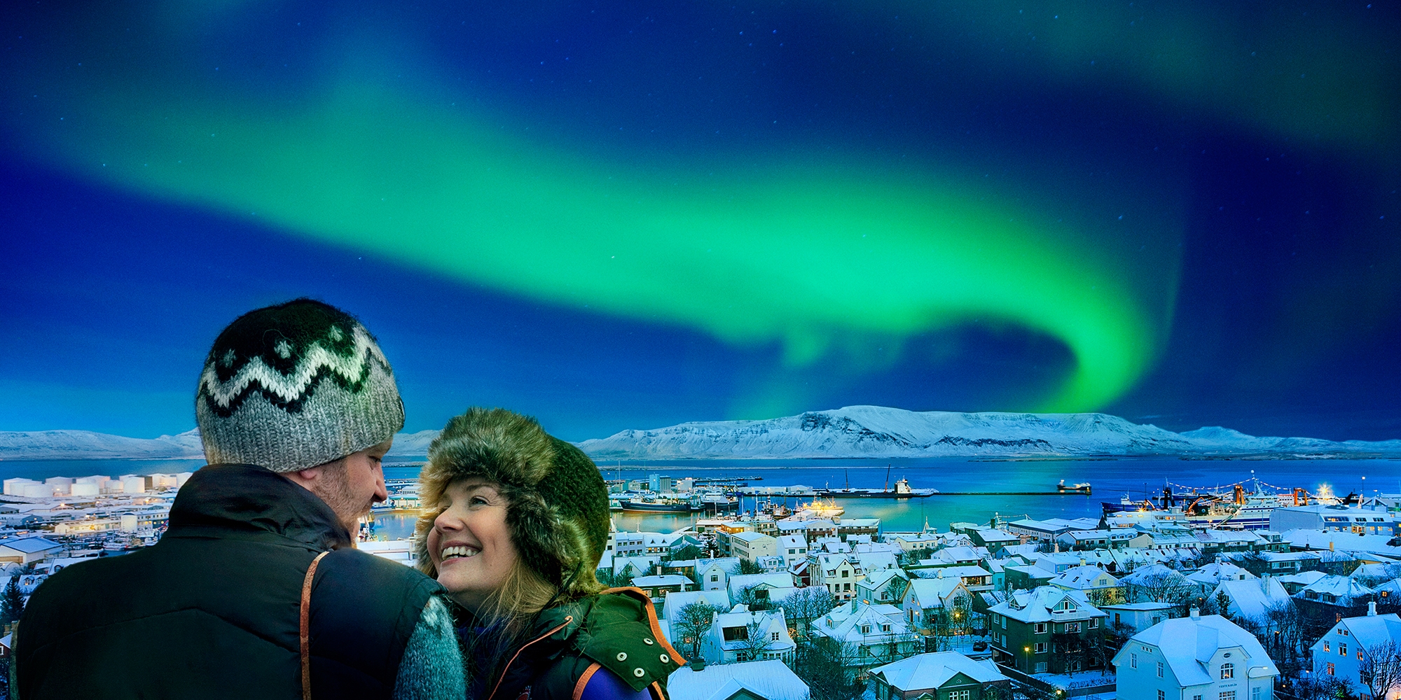 A couple enjoys a romantic break in Iceland with the northern lights dancing in the background