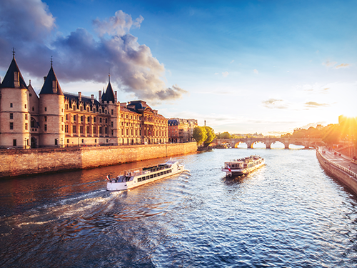A boat sails along the River Seine in Paris, with a view of the city to the left of the image