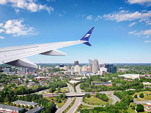 An Icelandair plane flying overhead Raleigh Durham on a bright sunny day 