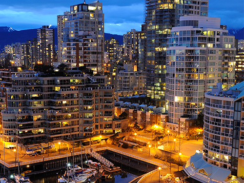 Hafnarbakkinn í Vancouver í Kanada að kvöldi, sterk ljós lýsa upp göturnar.