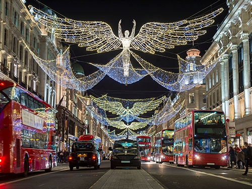 Traditional red London double-decker buses on Regent street, decorated with Christmas lights