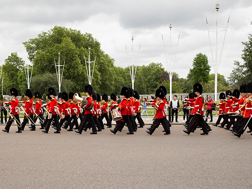 The Royal Guard in London marching down a street on an overcast day