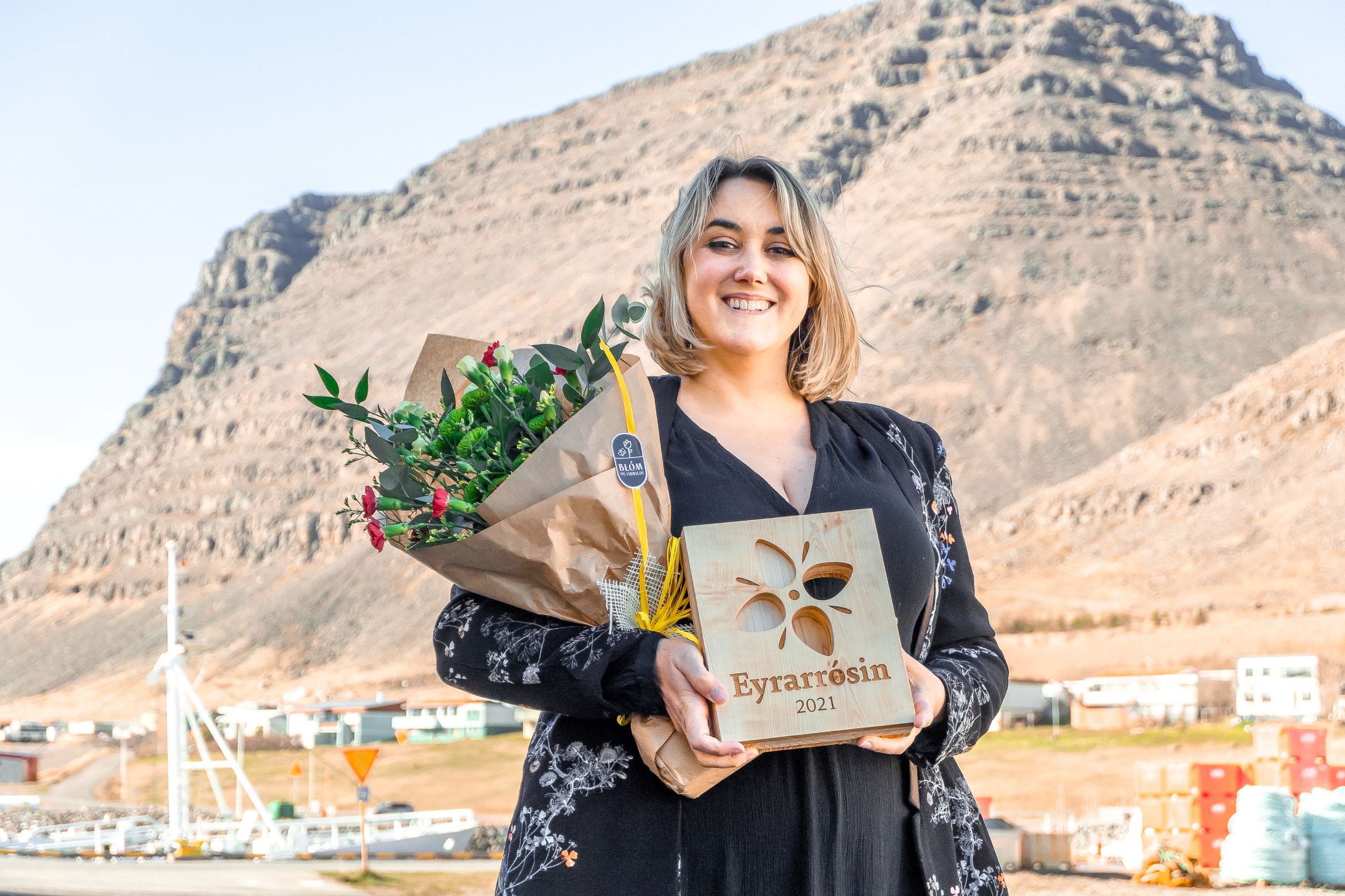 Greta Clough pictured in Patreksfjordur holding a large bunch of flowers and the Eyrarrosin award