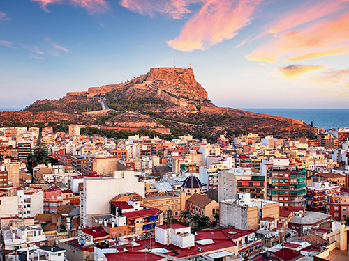 An overhead view of Alicante with Mount Benacantil in view to the rear of the picture, behind the colourful town 