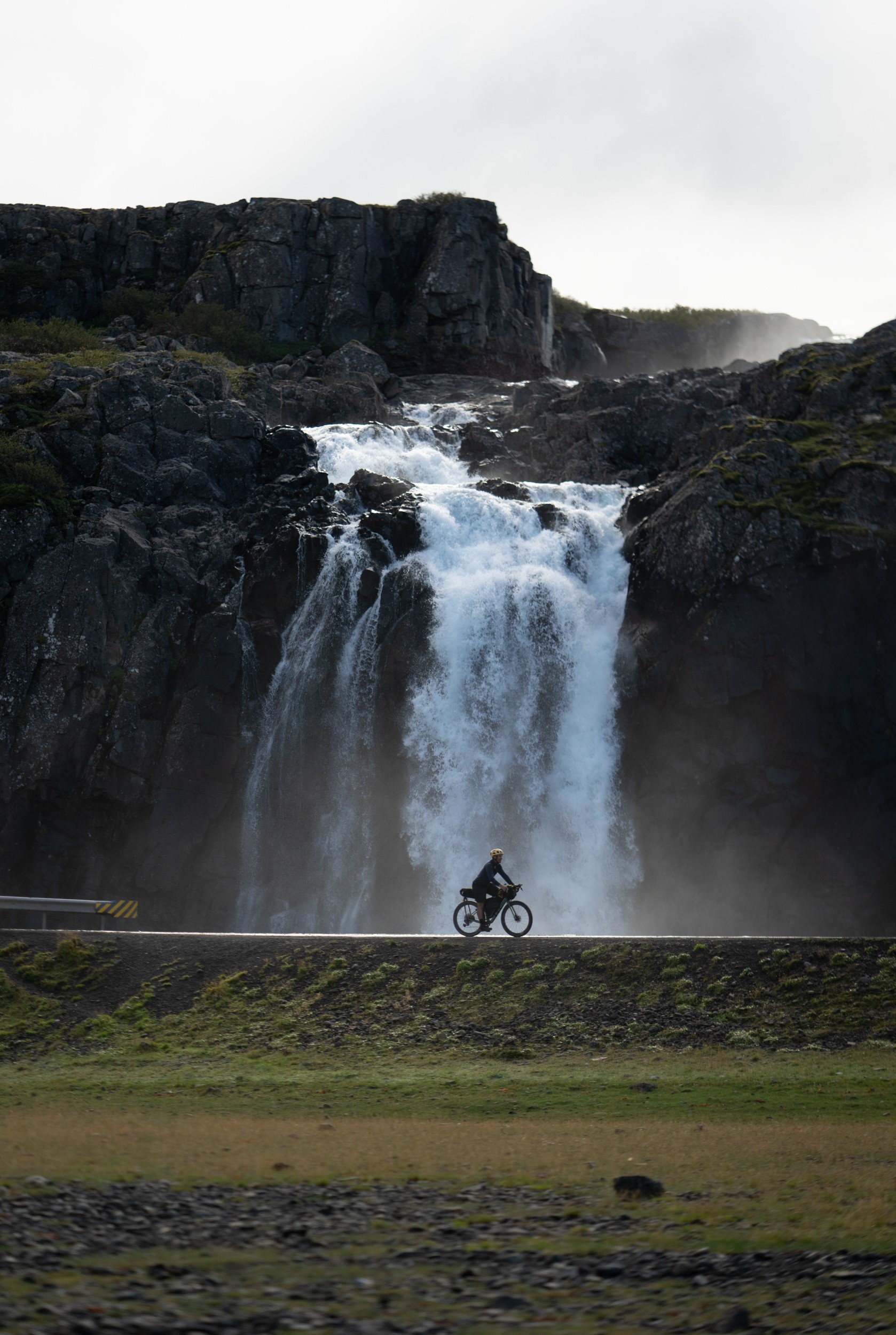 Cyclist riding by a waterfall