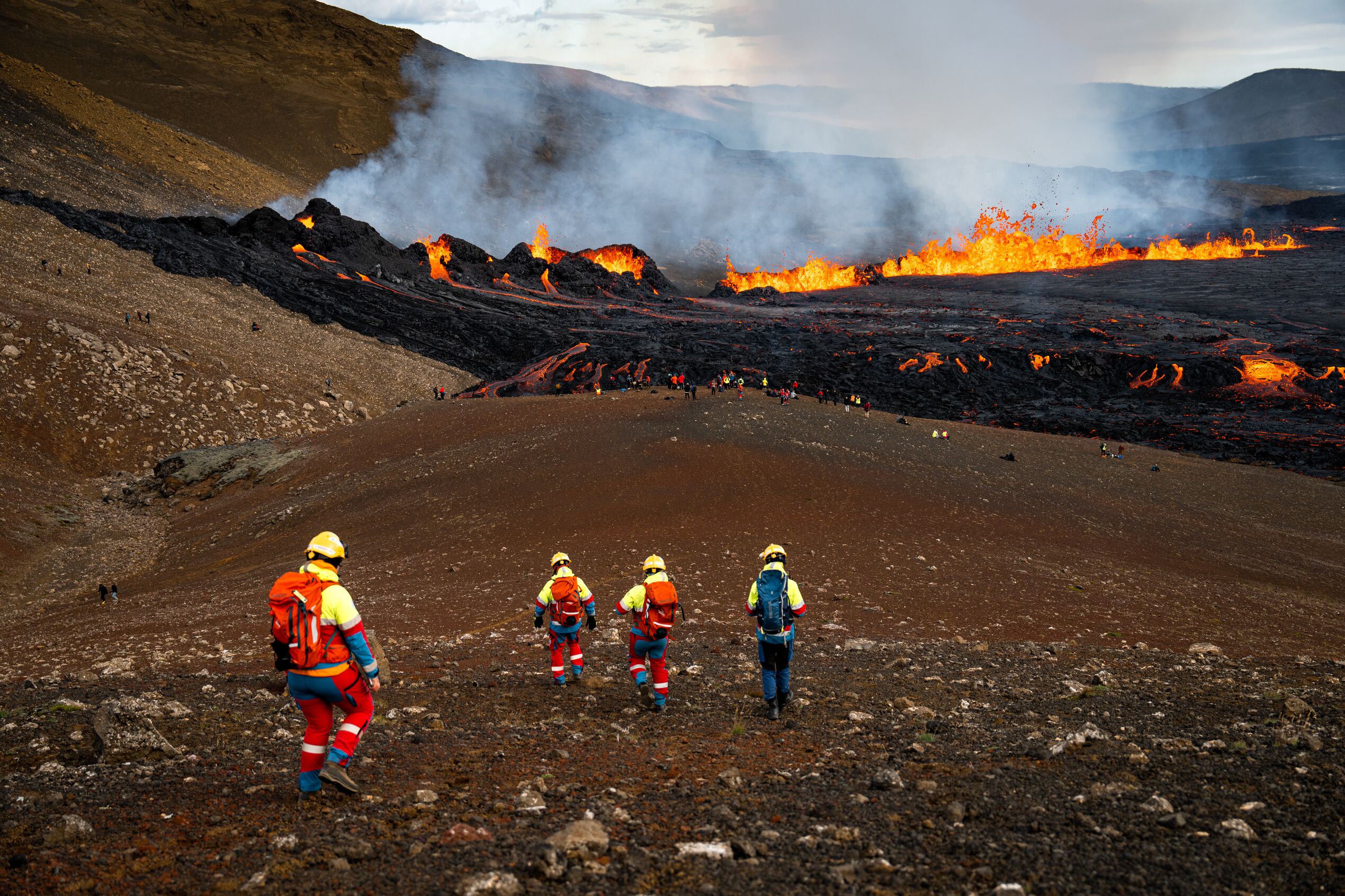 People and search-and-rescue volunteers walking to the volcanic eruption in 2022