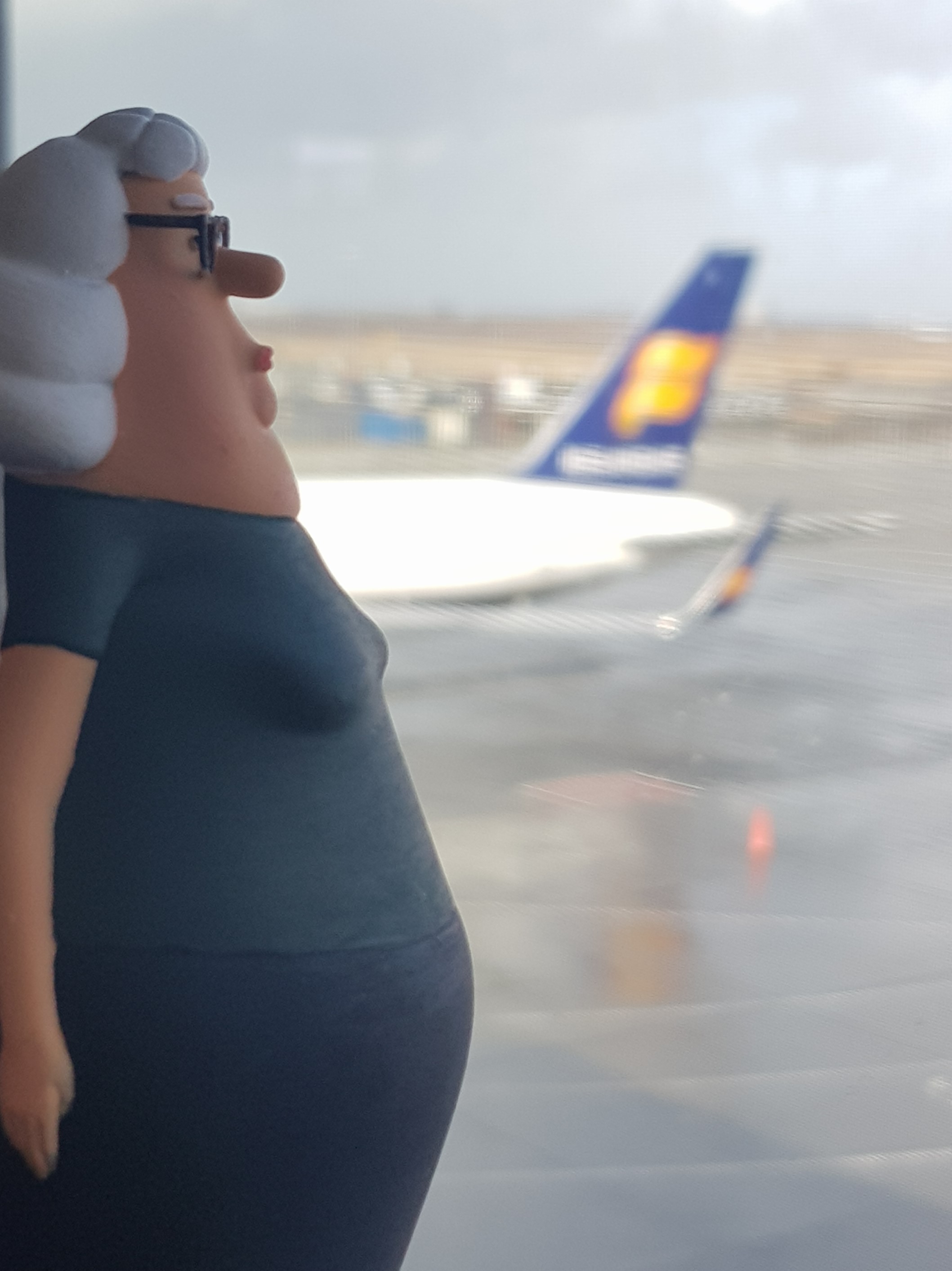 The woman of the couple from the film Yes People pictured looking stern as she looks out on to the Icelandair plane stationed in the runway
