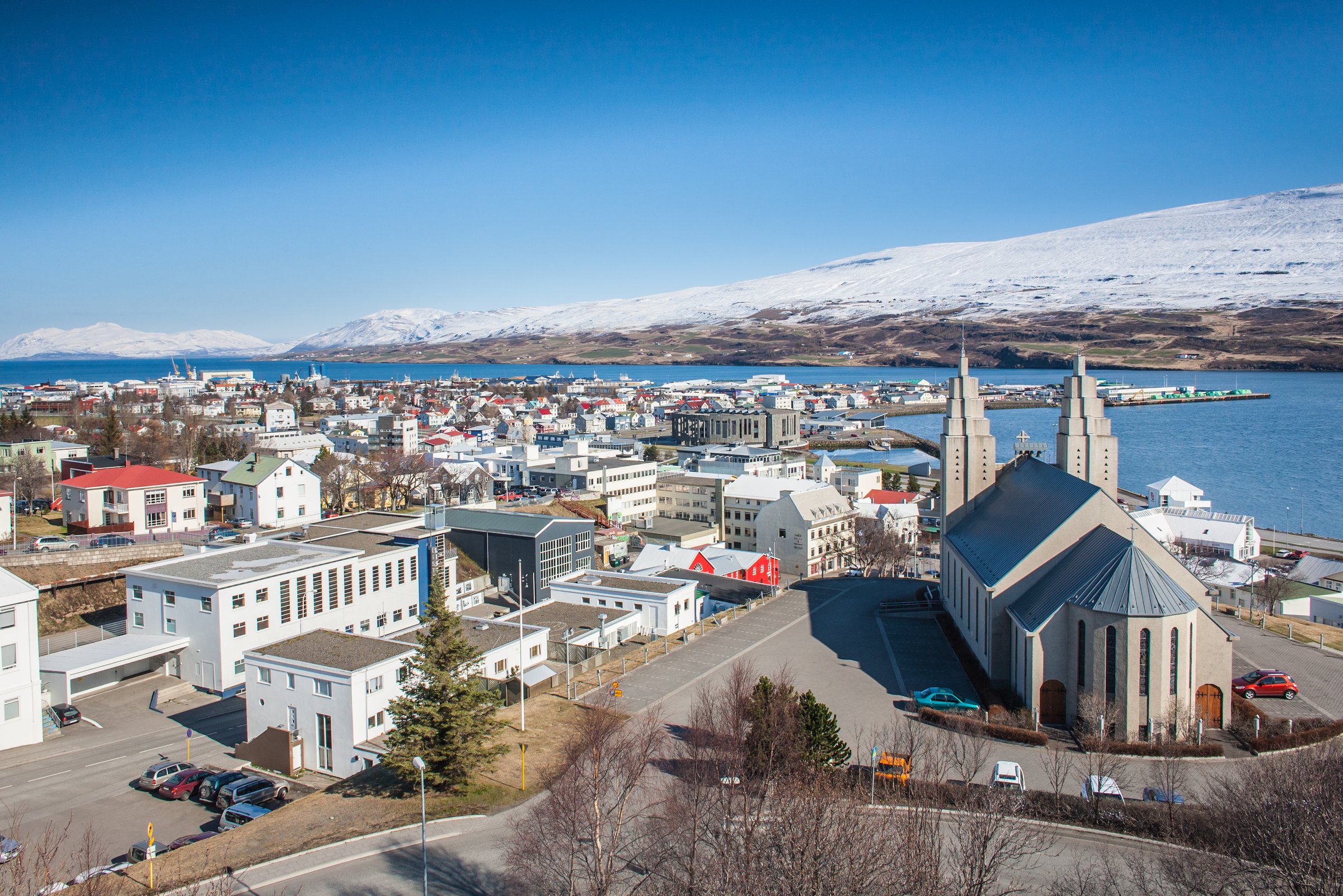 An aerial view of downtown Akureyri with the fjord in the background and the distinctive town church in the foreground