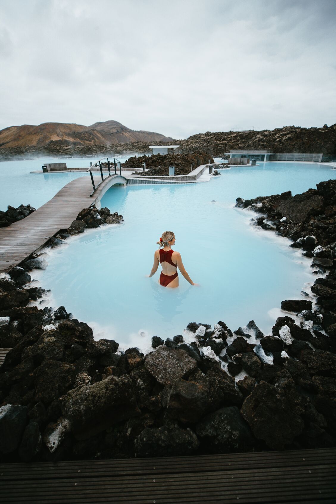 Asa Steinars pictured wearing a red bathing suit in the milky blue waters of the Blue Lagoon in Iceland