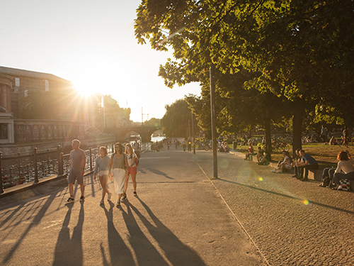 One of Berlin's many green parks basking in the evening glow, with a family walking in the forefront