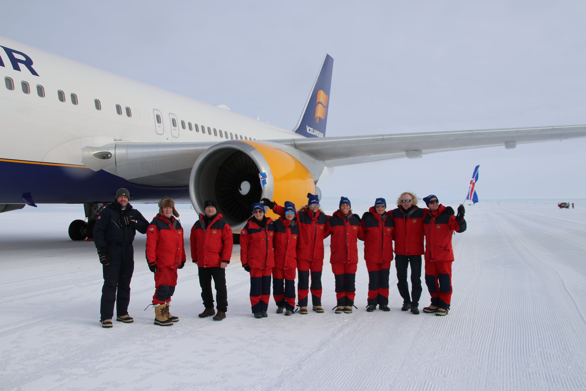 The Icelandair flight crew landing in Antarctica pictured in front of the Icelandair aircraft in red snow suits