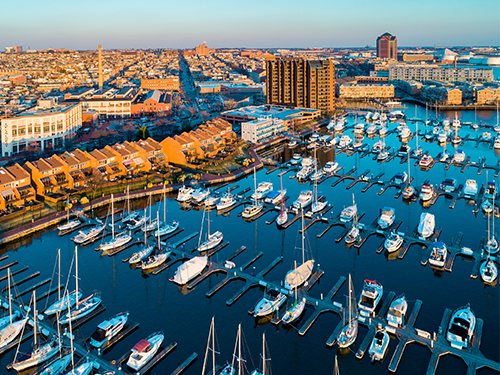 An overhead view of the harbour in Baltimore, lit up in late afternoon sun  