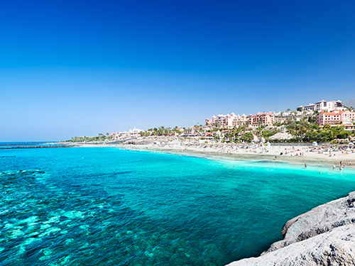 Grænleitur hafflötur og gulur sandur á Playa del Duque á suðurhluta Tenerife, rétt norðan við Costa Adeje.