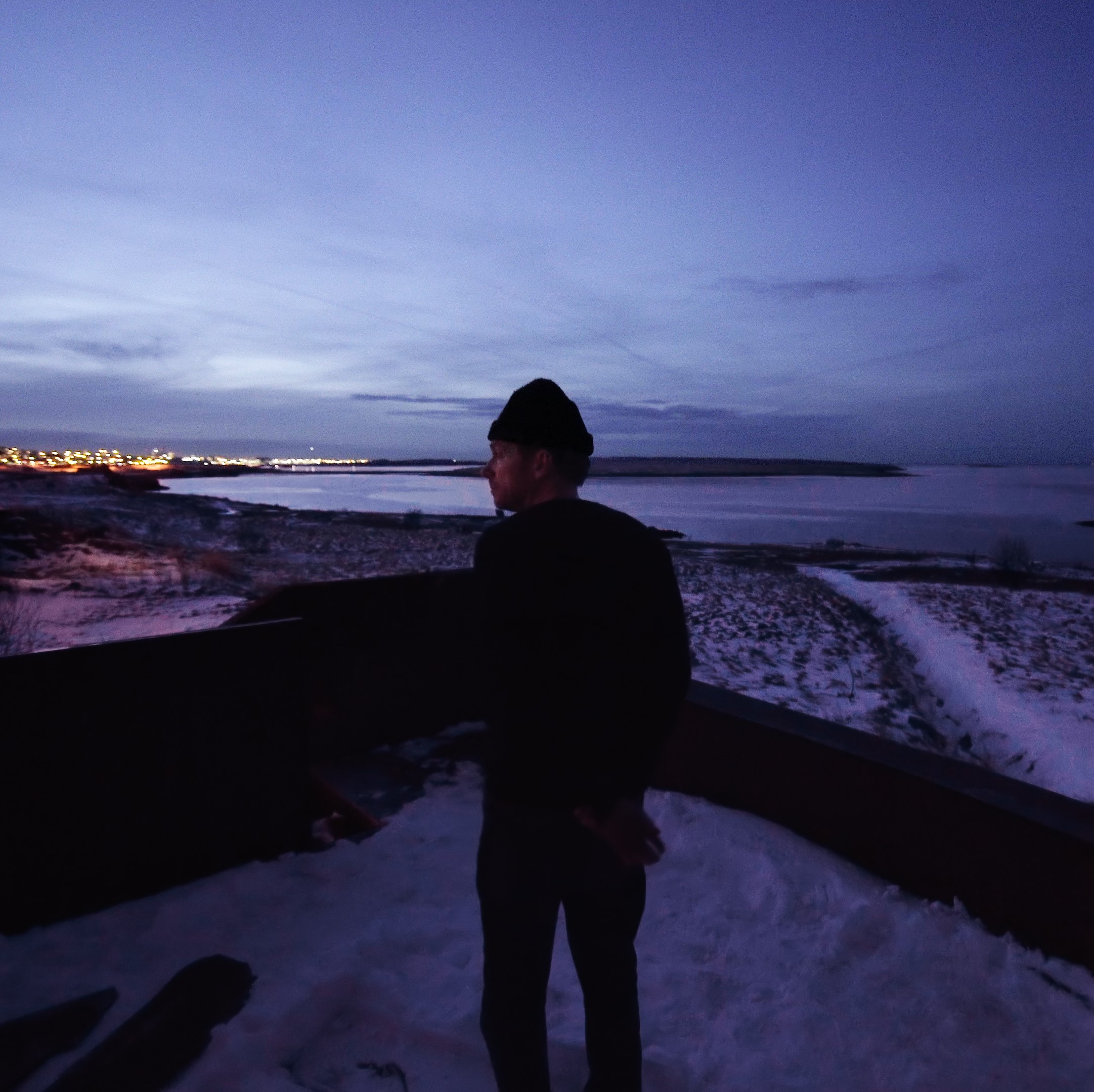 Damon Albarn outside in twilight, with snow and view of bay. Photo credit: Matt Cronin